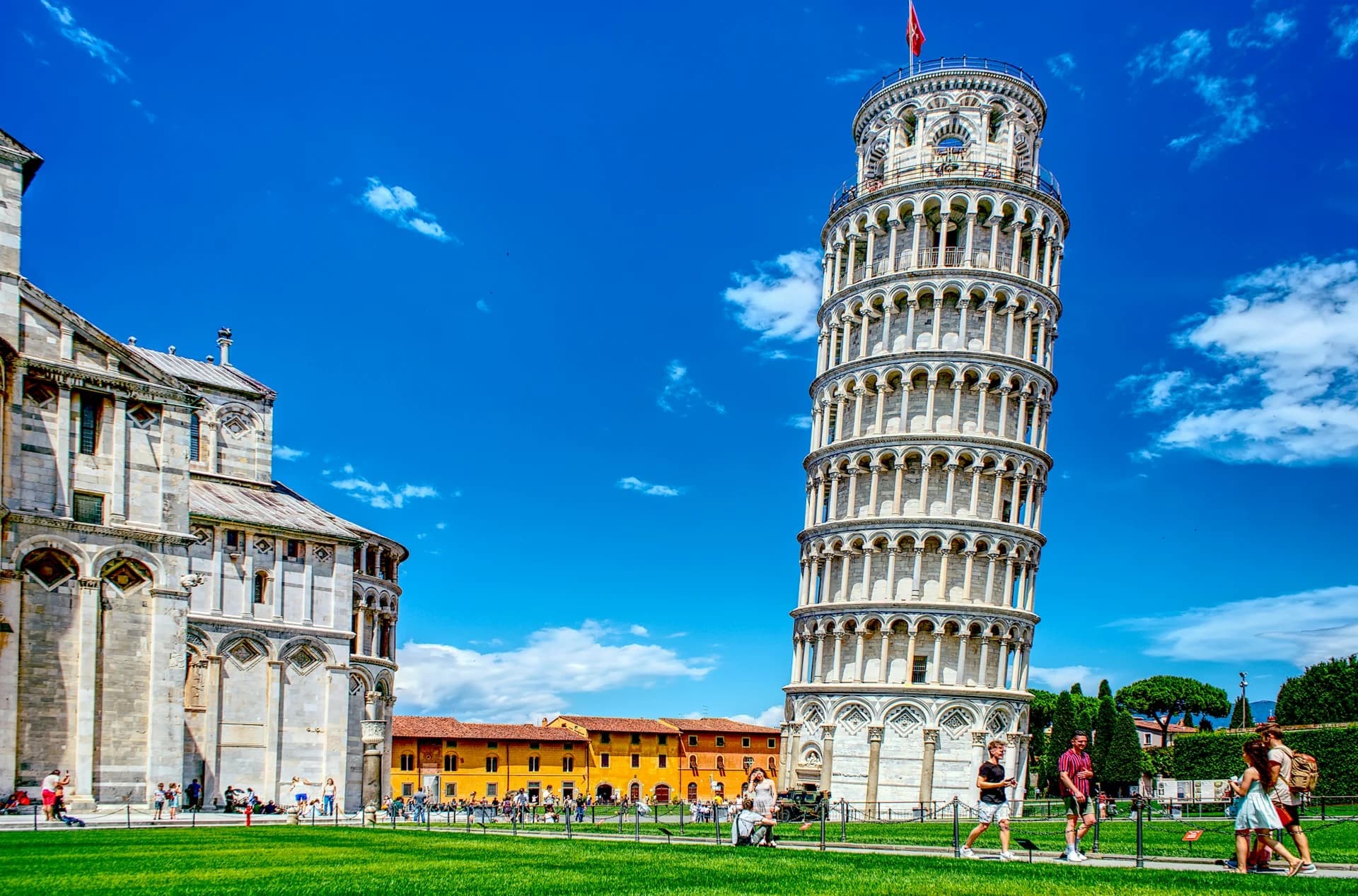 The Leaning Tower of Pisa and the white marble Cathedral on the lawns of Piazza dei Miracoli