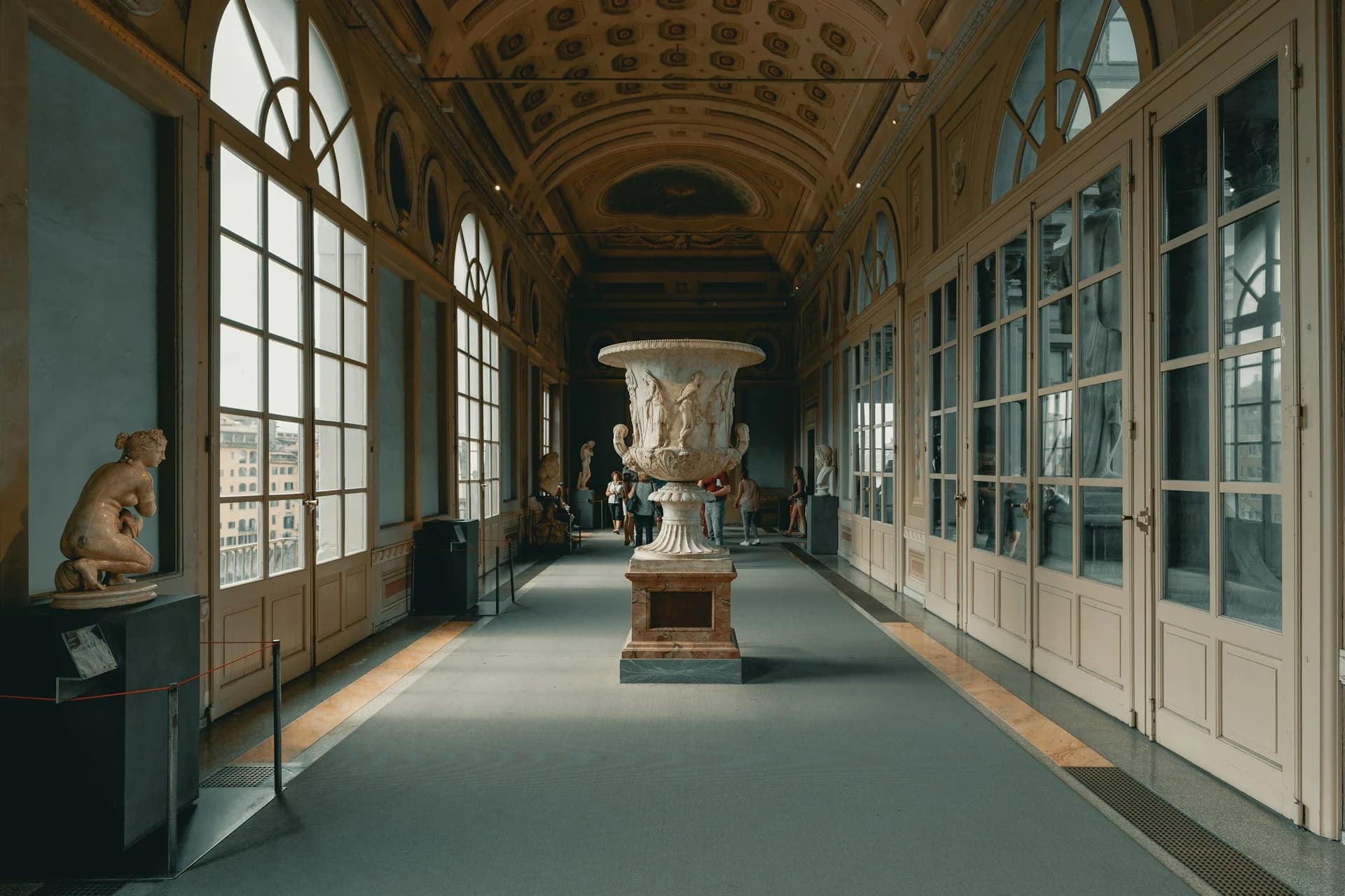 The long Vasari corridor of statues and painted ceilings inside the Uffizi Gallery in Florence