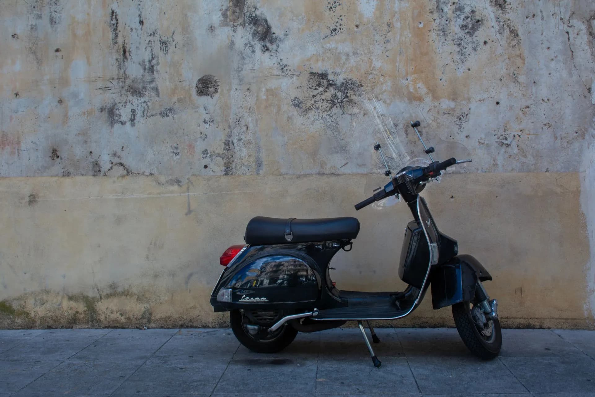 A line of pastel Vespa scooters parked on a cypress-lined road in the Chianti hills outside Florence