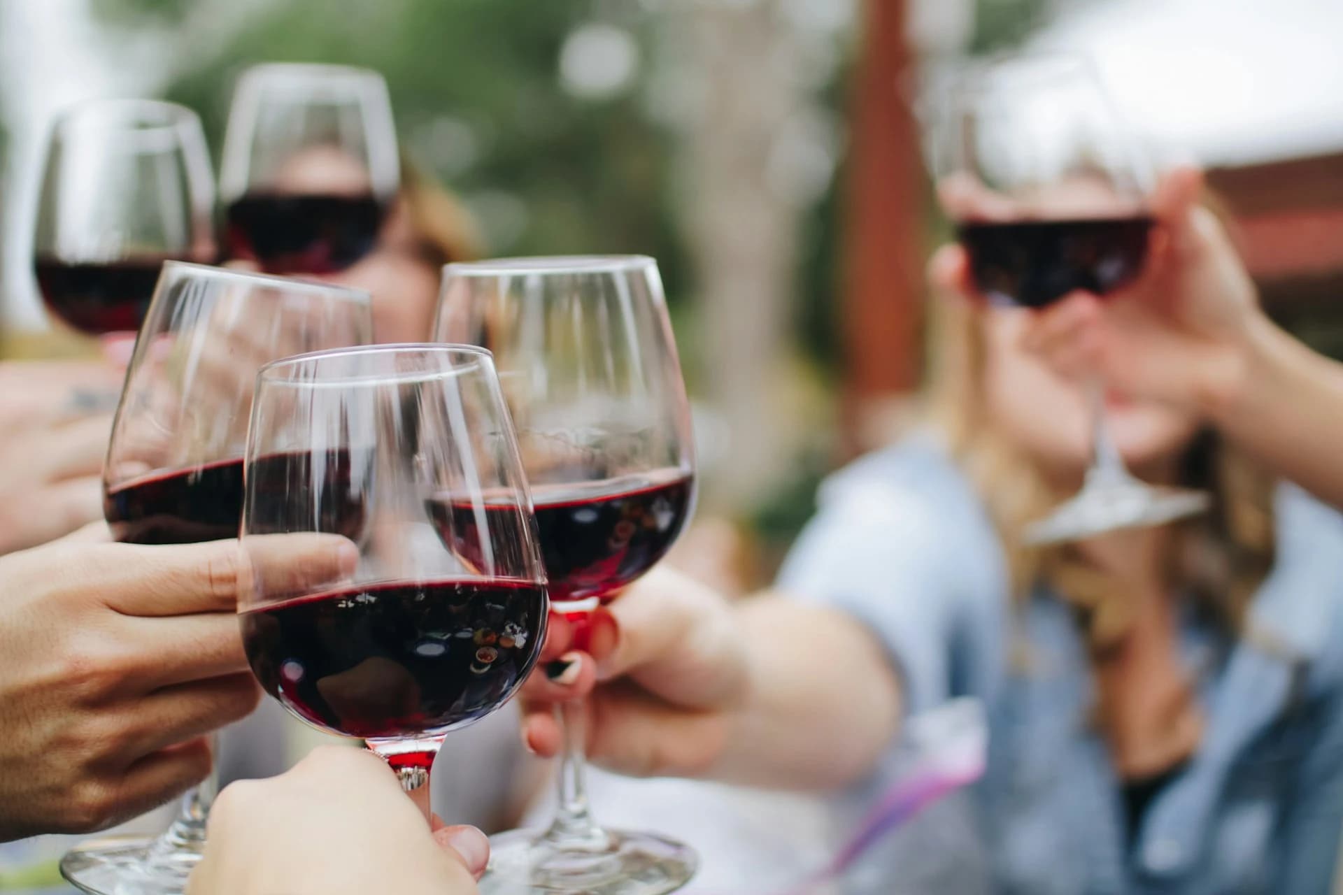 Glasses of Chianti Classico on a stone ledge above terraced vineyards in the Tuscan hills near Florence